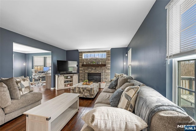 living room featuring dark wood-style flooring and a fireplace