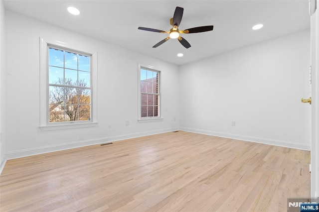 empty room featuring baseboards, visible vents, light wood-style flooring, and recessed lighting