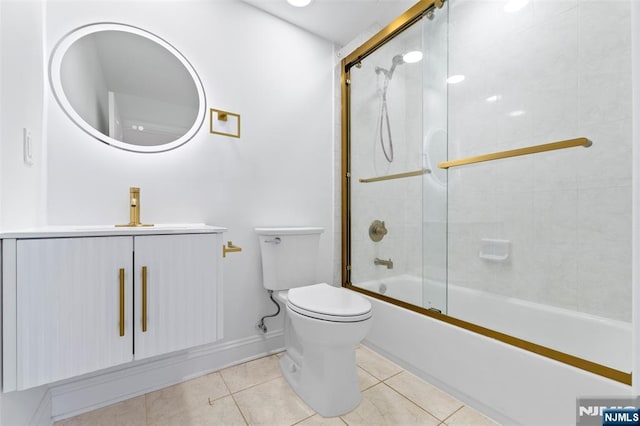 full bathroom featuring baseboards, toilet, tile patterned floors, vanity, and shower / bath combination with glass door