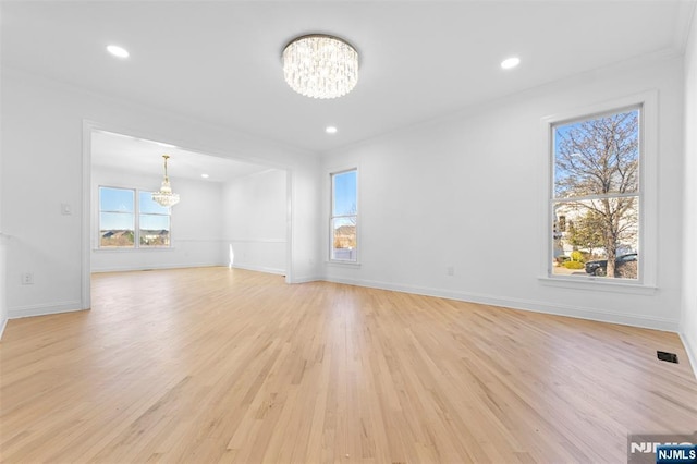 spare room with recessed lighting, baseboards, a chandelier, and light wood-type flooring