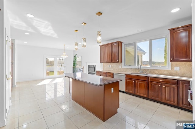 kitchen featuring a sink, backsplash, dishwasher, a center island, and light tile patterned floors