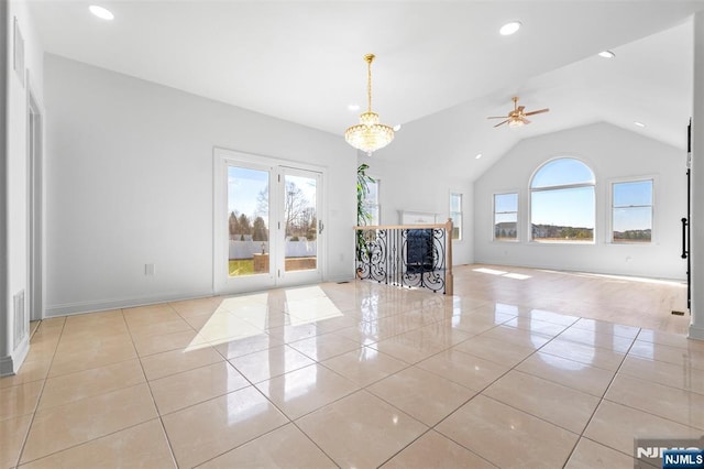unfurnished living room with light tile patterned flooring, a wealth of natural light, vaulted ceiling, and ceiling fan with notable chandelier