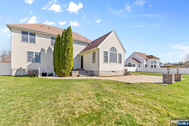 rear view of house with a lawn, fence, and a patio area