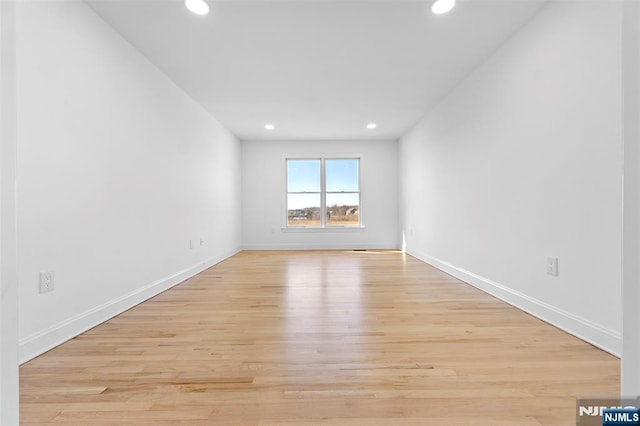 unfurnished room with baseboards, light wood finished floors, and recessed lighting