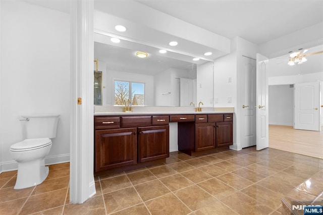 full bathroom featuring baseboards, double vanity, a sink, and recessed lighting