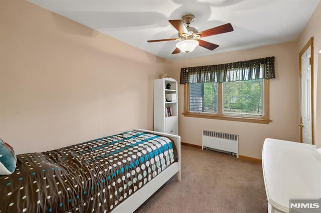 carpeted bedroom featuring baseboards, a ceiling fan, and radiator heating unit