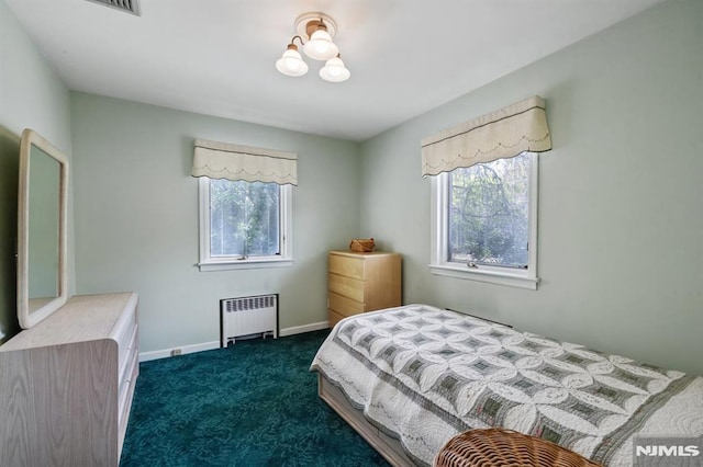 bedroom featuring dark carpet, baseboards, and radiator heating unit
