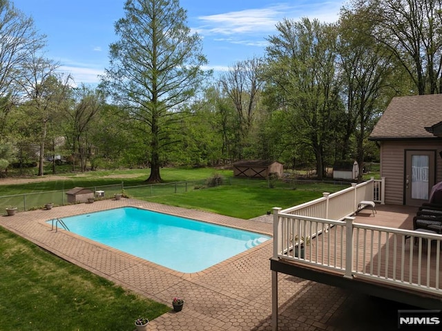 view of pool featuring a lawn, a fenced backyard, a deck, and a fenced in pool