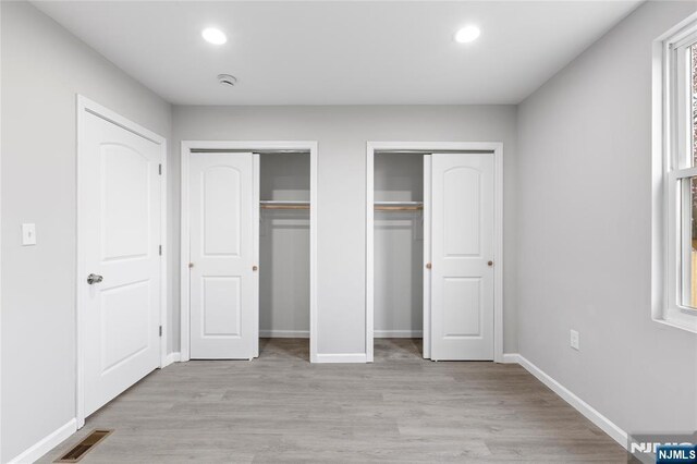 1457 67th St, North Bergen, NJ 07047 - unfurnished bedroom featuring recessed lighting, visible vents, multiple closets, and light wood-style flooring