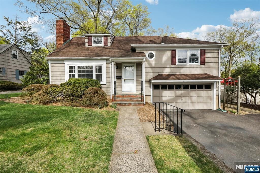 529 Ardmore Rd, Ho-Ho-Kus, NJ 07423 - split level home featuring a garage, a front lawn, aphalt driveway, roof with shingles, and a chimney