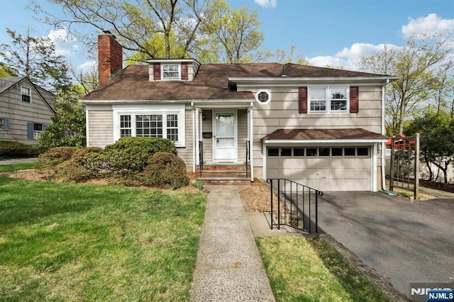 split level home featuring a garage, a front lawn, aphalt driveway, roof with shingles, and a chimney