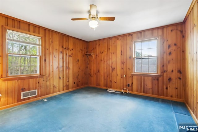 unfurnished room featuring visible vents, carpet, and a wealth of natural light