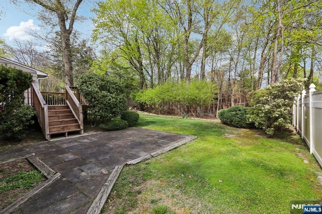 view of yard with fence, a patio, a deck, and stairway