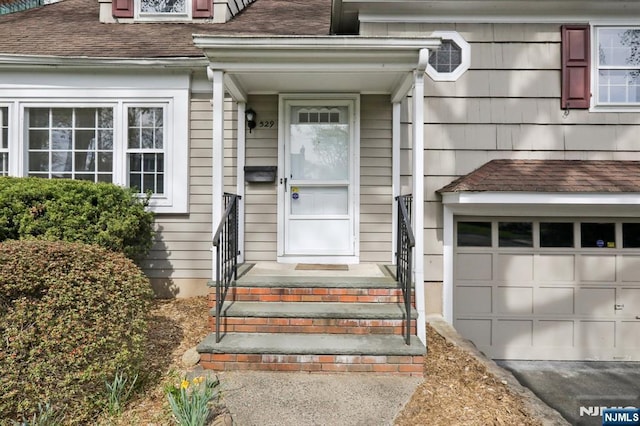 view of exterior entry with a shingled roof