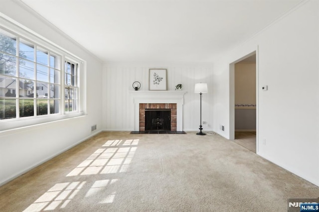 unfurnished living room featuring carpet floors, baseboards, a fireplace, and visible vents