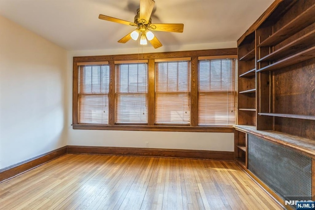unfurnished room featuring baseboards, ceiling fan, and light wood-style flooring