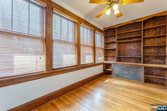 unfurnished room with ceiling fan, a healthy amount of sunlight, light wood-style flooring, and baseboards