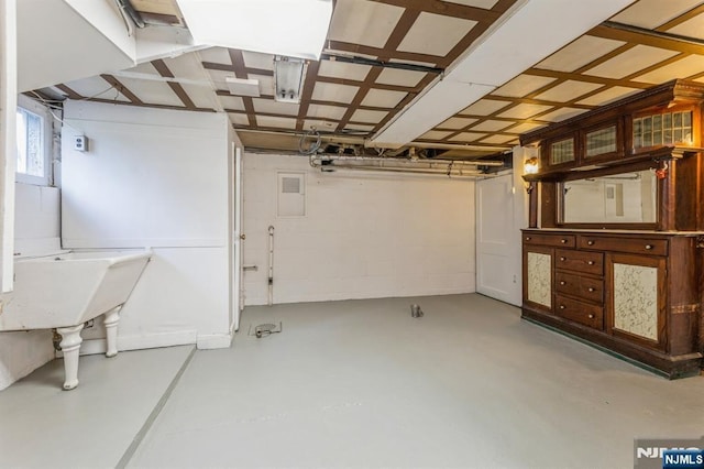 basement with concrete block wall and a sink