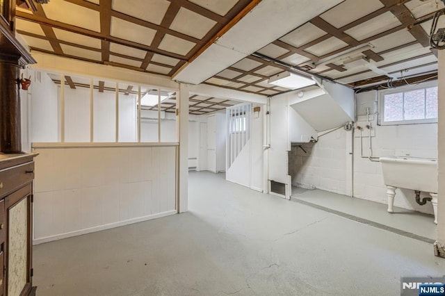 basement featuring stairs and a sink