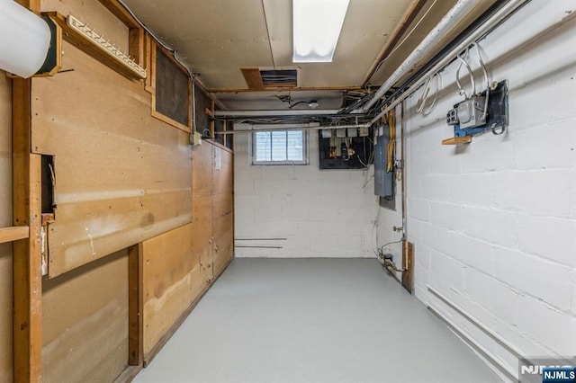 below grade area featuring concrete block wall and electric panel