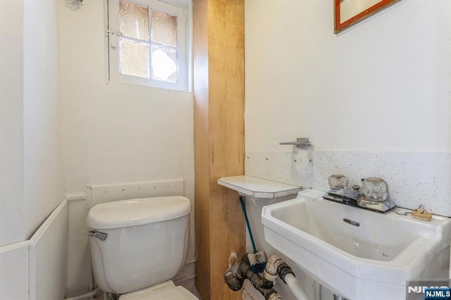 half bath featuring toilet and a sink