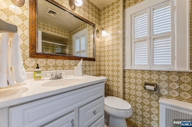 full bathroom featuring visible vents, wallpapered walls, vanity, and a healthy amount of sunlight