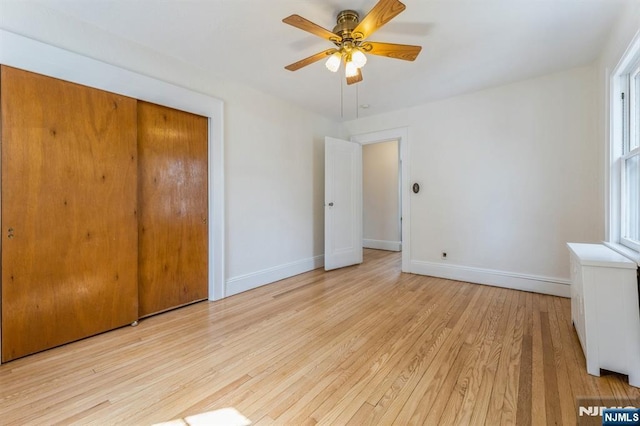 unfurnished bedroom with a closet, light wood finished floors, and baseboards