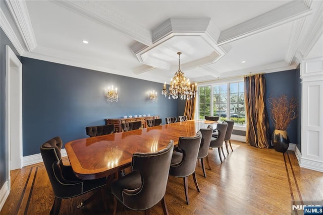 dining area featuring wood finished floors, a chandelier, coffered ceiling, ornamental molding, and beam ceiling