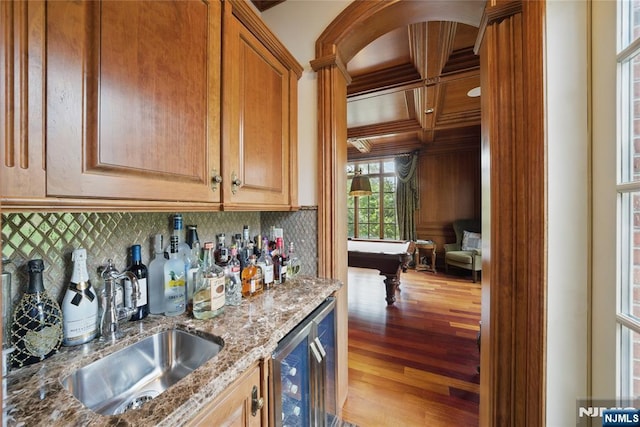bar featuring wet bar, wood finished floors, decorative backsplash, and a sink