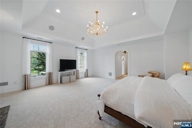 bedroom featuring a chandelier, arched walkways, a tray ceiling, carpet, and ornamental molding