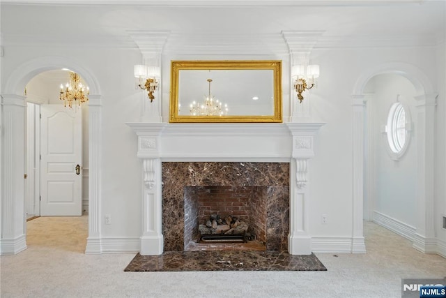 living area featuring arched walkways, carpet, a tile fireplace, and an inviting chandelier