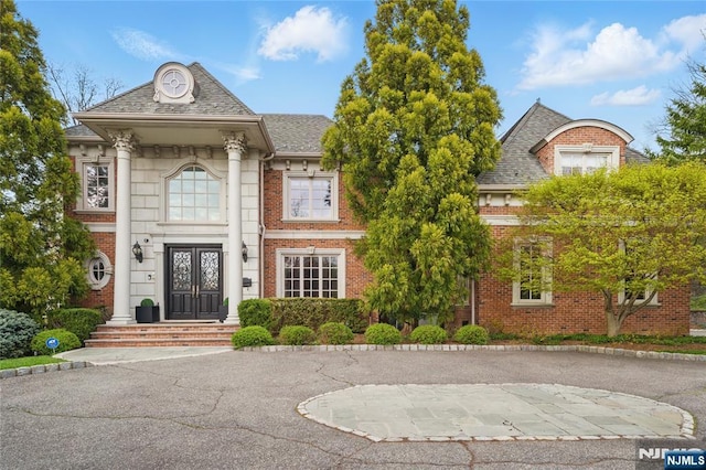 view of front of house with brick siding and french doors