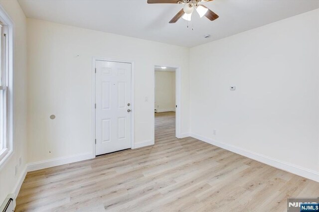 546 Morris St, Orange, NJ 07050 - unfurnished room with baseboards, light wood-style flooring, a baseboard radiator, and a ceiling fan