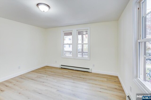 546 Morris St, Orange, NJ 07050 - empty room featuring baseboard heating, baseboards, and wood finished floors
