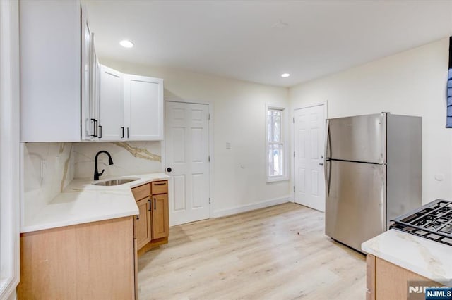 546 Morris St, Orange, NJ 07050 - kitchen with light countertops, freestanding refrigerator, decorative backsplash, light wood finished floors, and a sink