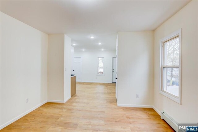 546 Morris St, Orange, NJ 07050 - empty room with baseboards, light wood-type flooring, a baseboard heating unit, and recessed lighting
