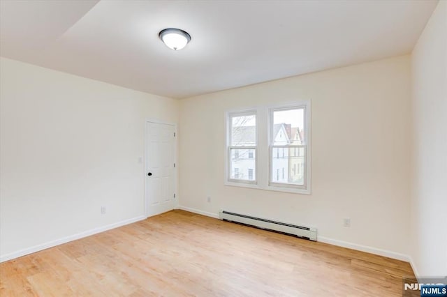 546 Morris St, Orange, NJ 07050 - empty room featuring light wood-style floors, a baseboard radiator, and baseboards