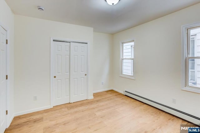 546 Morris St, Orange, NJ 07050 - unfurnished bedroom with baseboard heating, light wood-type flooring, a closet, and baseboards
