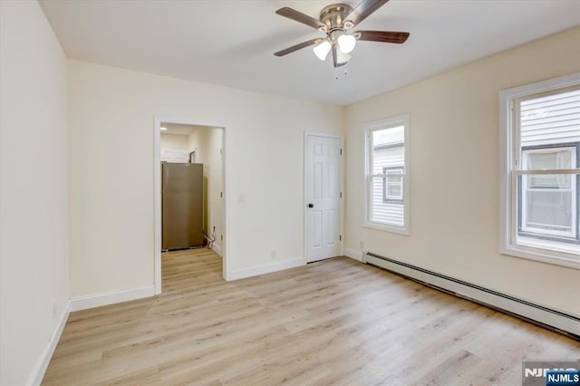 546 Morris St, Orange, NJ 07050 - unfurnished bedroom with light wood-style floors, ceiling fan, freestanding refrigerator, a baseboard radiator, and baseboards