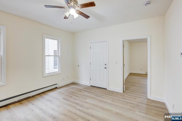 546 Morris St, Orange, NJ 07050 - unfurnished bedroom featuring a baseboard radiator, light wood finished floors, ceiling fan, and baseboards