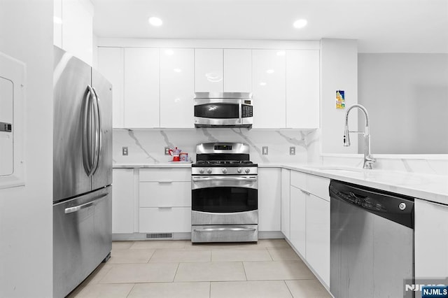 kitchen with backsplash, appliances with stainless steel finishes, modern cabinets, and white cabinets