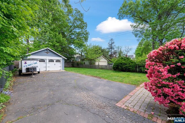 view of yard with a detached garage and an outbuilding