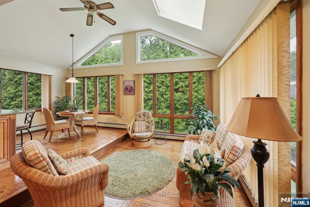 sunroom / solarium with lofted ceiling, wood finished floors, healthy amount of natural light, and a baseboard radiator