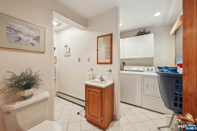 washroom with a baseboard radiator, separate washer and dryer, and light tile patterned floors