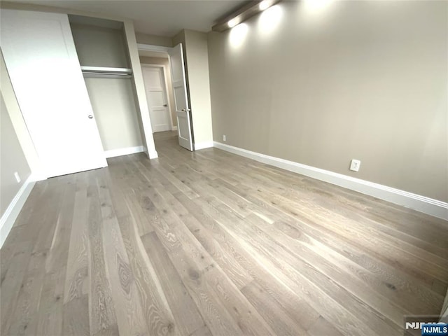 300 Winston Dr Unit 1722, Cliffside Park, NJ 07010 - unfurnished bedroom featuring a closet, baseboards, and wood finished floors
