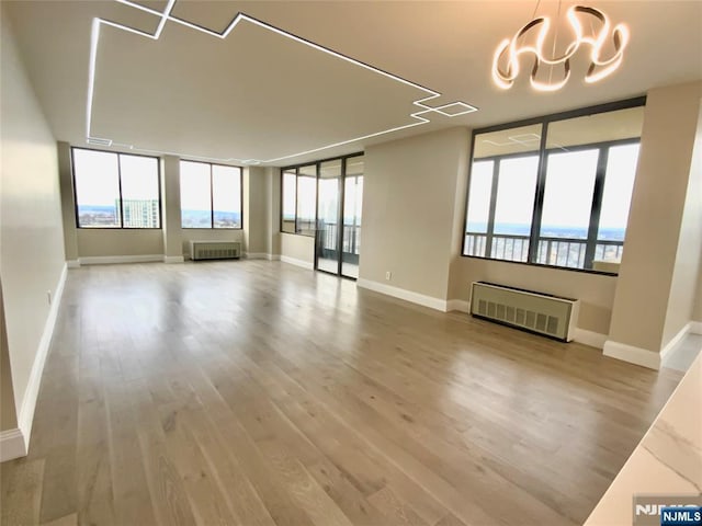 300 Winston Dr Unit 1722, Cliffside Park, NJ 07010 - spare room with an inviting chandelier, radiator, and wood finished floors