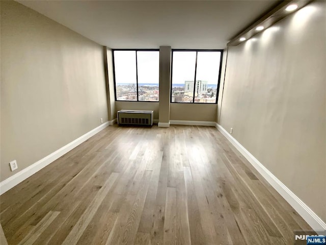 300 Winston Dr Unit 1722, Cliffside Park, NJ 07010 - unfurnished room with radiator heating unit, baseboards, and wood finished floors