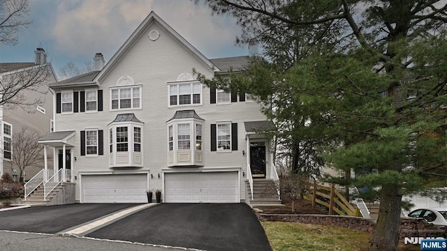 townhome / multi-family property with a garage and aphalt driveway