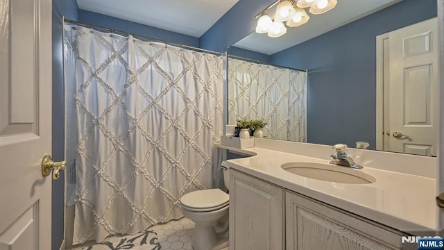 bathroom with a notable chandelier, curtained shower, vanity, and toilet