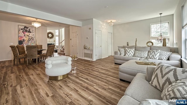living area with a chandelier, wood finished floors, and baseboards